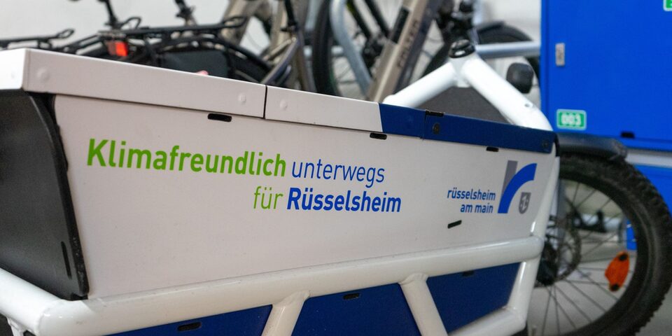 Lastenrad mit der Aufschrift "Klimafreundlich unterwegs für Rüsselsheim" und Rüsselsheim-Logo.