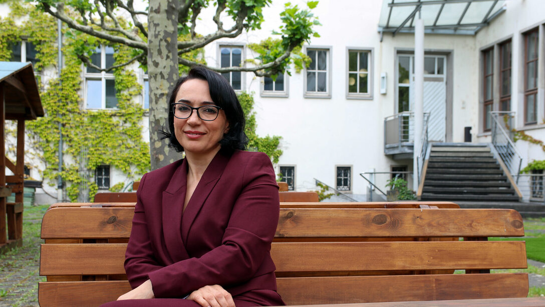 Ouarda Bouy sitzt im Innenhof des Rathaus Rüsselsheim