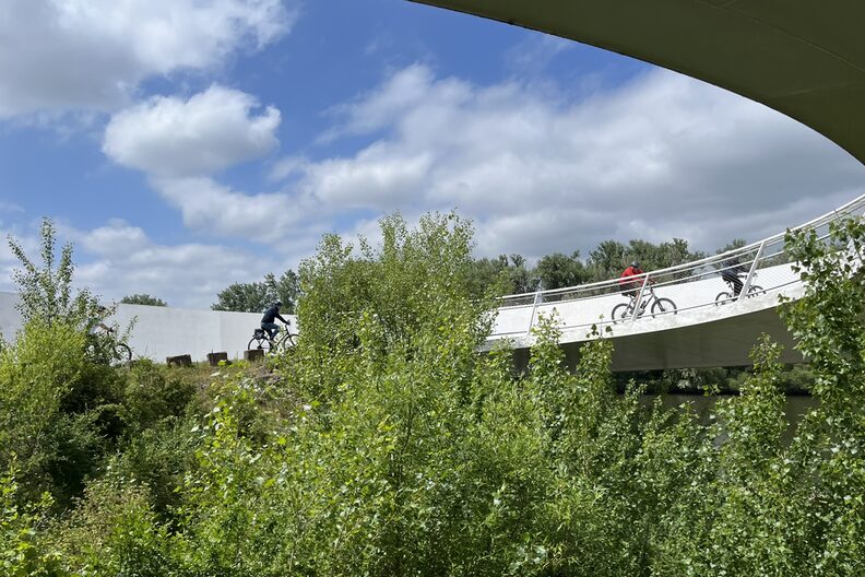 Fahrradfahrer fahren über die Ölhafenbrücke bei Raunheim.