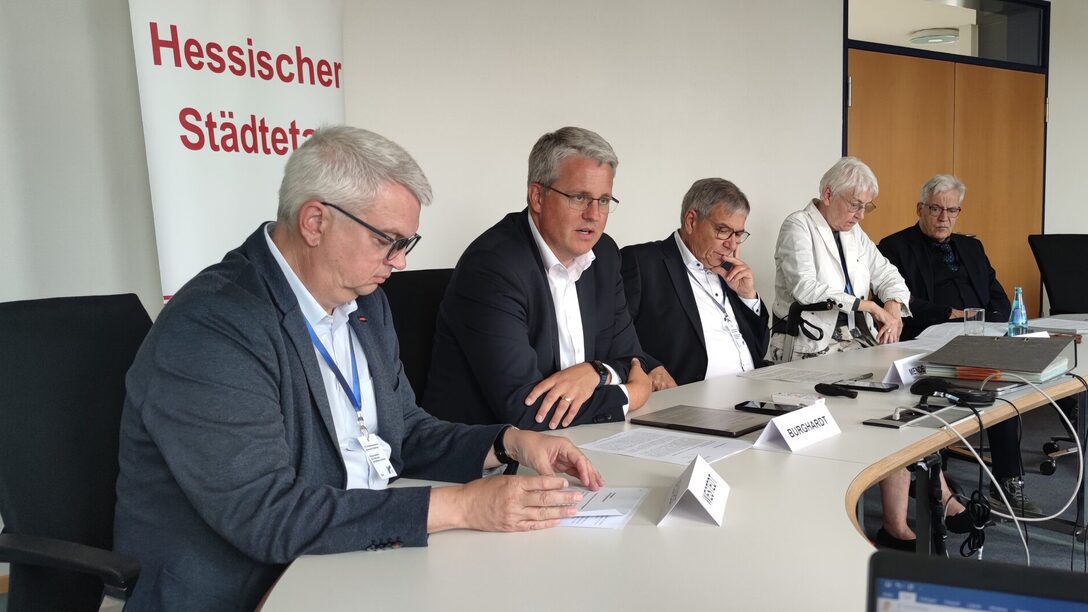 An einem Tisch vor einem Rollup mit der Aufschrift "Hessischer Städtetag" sitzen (v.l.n.r.): Dirk Westedt (Vizepräsident des Hessischen Städtetages), Oberbürgermeister Patrick Burghardt, Gert-Uwe Mende (Präsident des Hessischen Städtetages), Gerda Weigel-Greilich (Zweite Vizepräsidentin des Hessischen Städtetages), Dr. Jürgen Dieter (Direktor des Hessischen Städtetages).