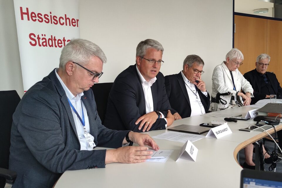 An einem Tisch vor einem Rollup mit der Aufschrift "Hessischer Städtetag" sitzen (v.l.n.r.): Dirk Westedt (Vizepräsident des Hessischen Städtetages), Oberbürgermeister Patrick Burghardt, Gert-Uwe Mende (Präsident des Hessischen Städtetages), Gerda Weigel-Greilich (Zweite Vizepräsidentin des Hessischen Städtetages), Dr. Jürgen Dieter (Direktor des Hessischen Städtetages).