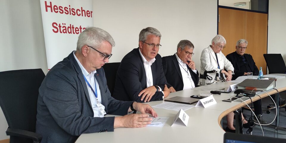 An einem Tisch vor einem Rollup mit der Aufschrift "Hessischer Städtetag" sitzen (v.l.n.r.): Dirk Westedt (Vizepräsident des Hessischen Städtetages), Oberbürgermeister Patrick Burghardt, Gert-Uwe Mende (Präsident des Hessischen Städtetages), Gerda Weigel-Greilich (Zweite Vizepräsidentin des Hessischen Städtetages), Dr. Jürgen Dieter (Direktor des Hessischen Städtetages).