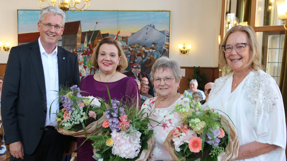 Die drei Geehrten mit Blumensträußen sowie Oberbürgermeister Patrick Burghardt.