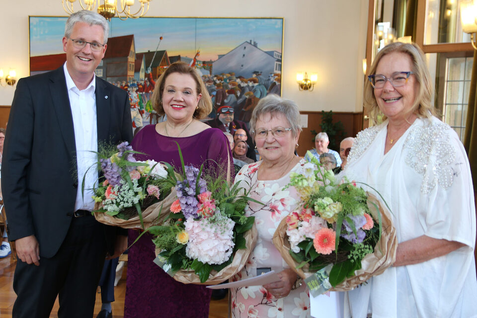 Die drei Geehrten mit Blumensträußen sowie Oberbürgermeister Patrick Burghardt.