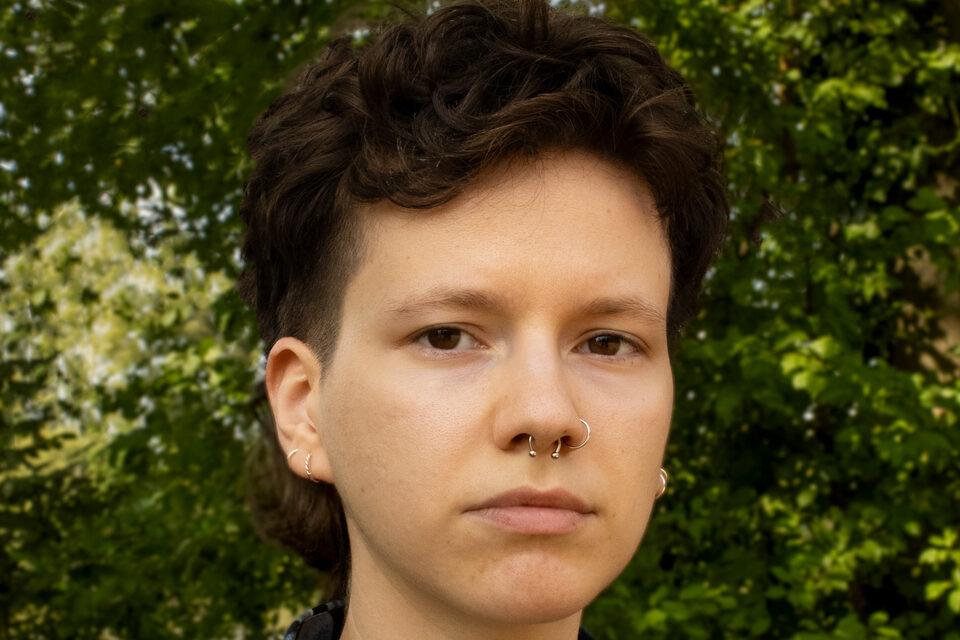 Melis Ntente steht vor Bäumen