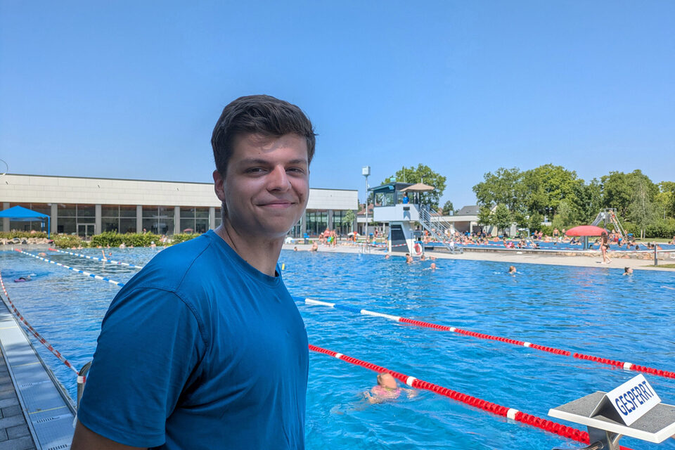 Nils Seewald steht im blauen T-Shirt vor den Startblöcken des Schwimmerbeckens im Freibad An der Lache.