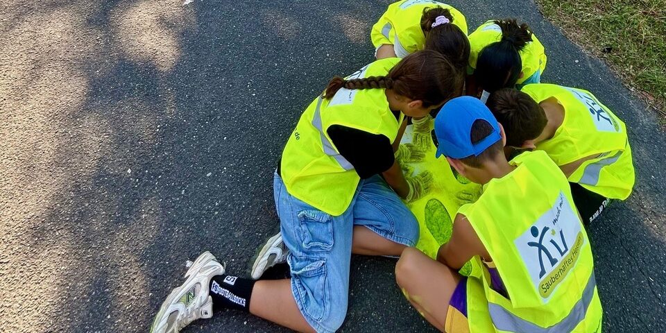 Kinder malen gelbe Füße auf den Asphalt