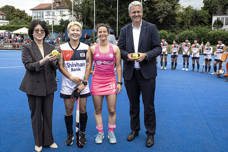 Ballübergabe beim Hockey-Spiel. Generalkonsulin von Südkorea, zwei Hockey-Spielerinnen und OB Burghardt.