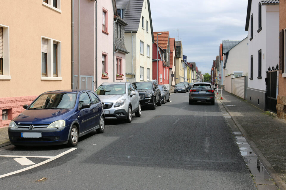 Ein Auto fährt in Richtung Bahnhof und Autos parken in der Gegenrichtung.