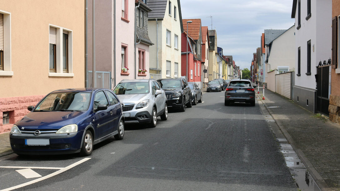 Ein Auto fährt in Richtung Bahnhof und Autos parken in der Gegenrichtung.