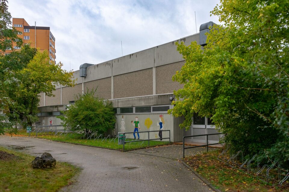 Eingang zur Sporthalle mit Gemälden an der Seitenwand.