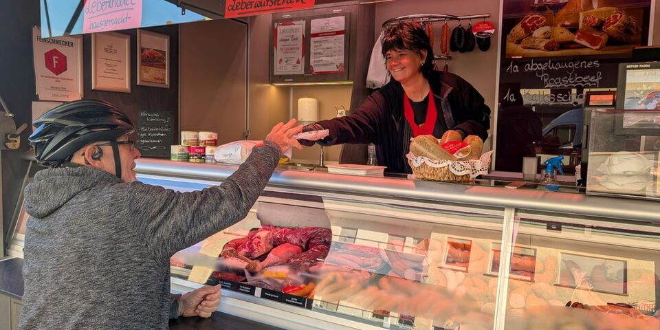 Kunde steht vor dem Verkaufswagen der Metzgerei Walz auf dem Wochenmarkt in Königstädten.