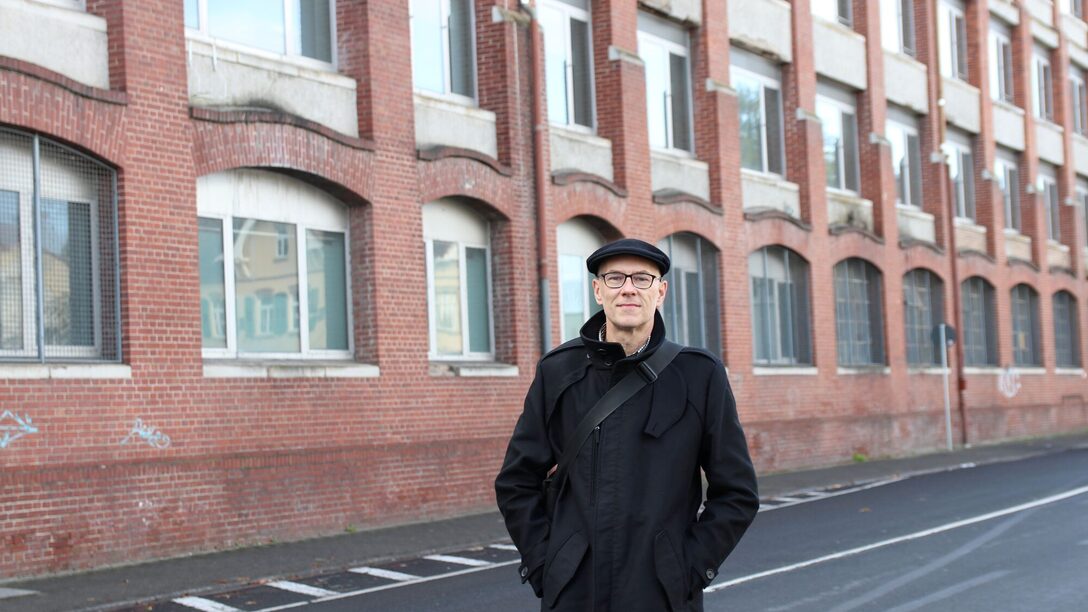 Jens Weisener steht vor der Fassade des Opel-Altwerks an der Weisenauer Straße.
