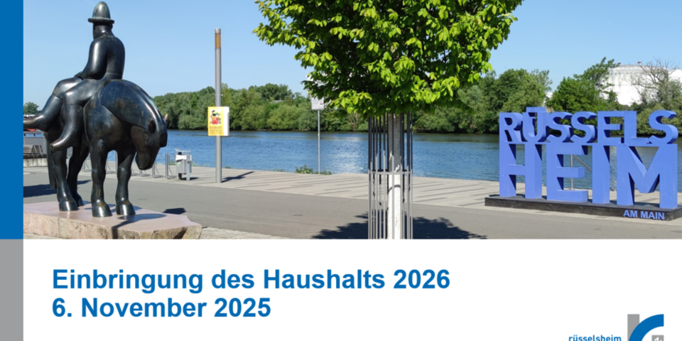 Deckblatt einer Powerpoint-Präsentation mit der Aufschrift "Einbringung des Haushalts 2026, 6. November 2025" und einem Foto, das den Main, den Leinreiter und den Rüsselsheim-Schriftzug im Sommer zeigt.