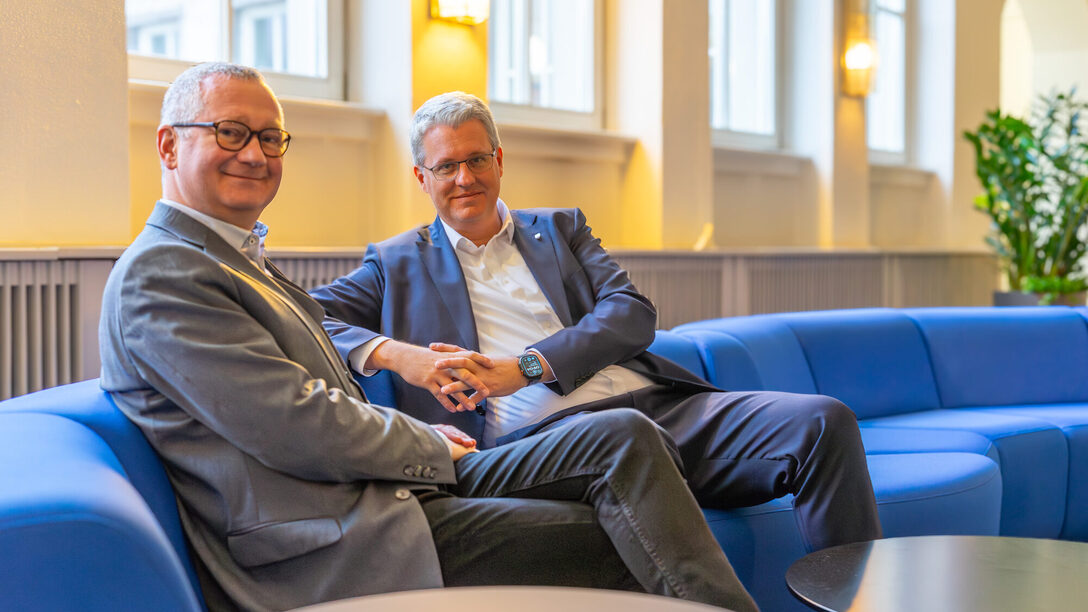 Geschäftsführer Regenstein und Oberbürgermeister Burghardt sitzen auf einem Sofa.