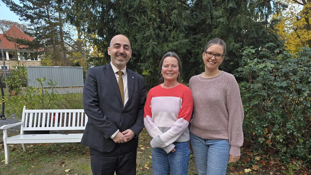 Drei Personen stehen im Garten des Haus der Senioren