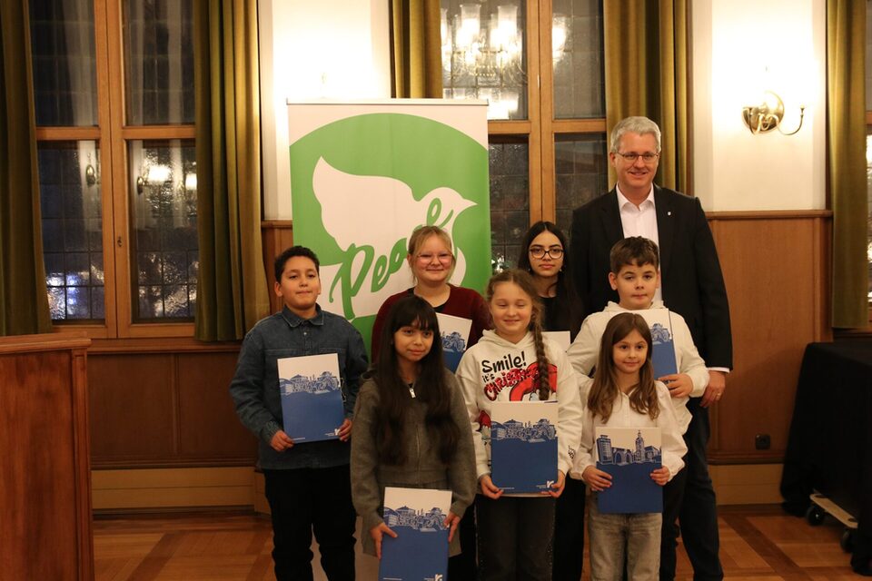 Kinder und Jugendliche stehen neben dem Oberbürgermeister und zeigen ihre Urkunden.