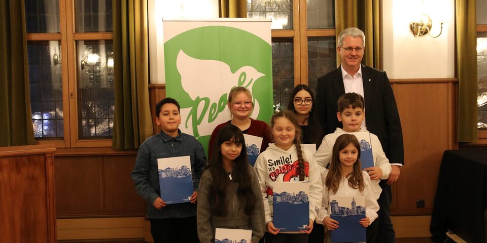 Kinder und Jugendliche stehen neben dem Oberbürgermeister und zeigen ihre Urkunden.