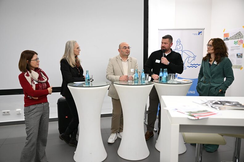 Stehen an Stehtischen mti weißen Hussen (v.l.n.r.): Susanne Roncka, Claudia C. Gotz, Hakan Inoglu, Jan Boese und Prof. Dr. Birte Frommer.