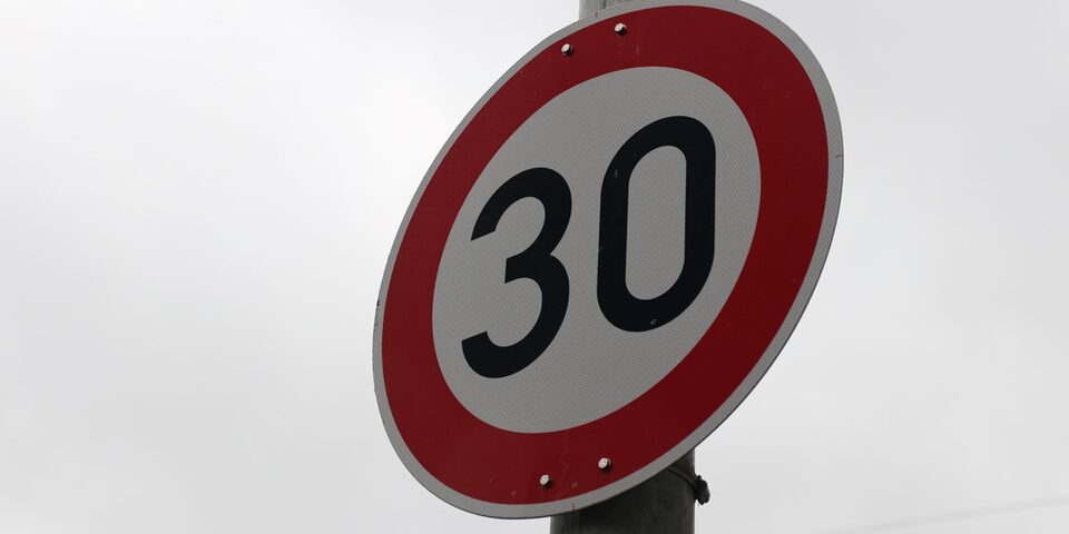 Verkehrsschild "Tempo 30" vor grauem Himmel