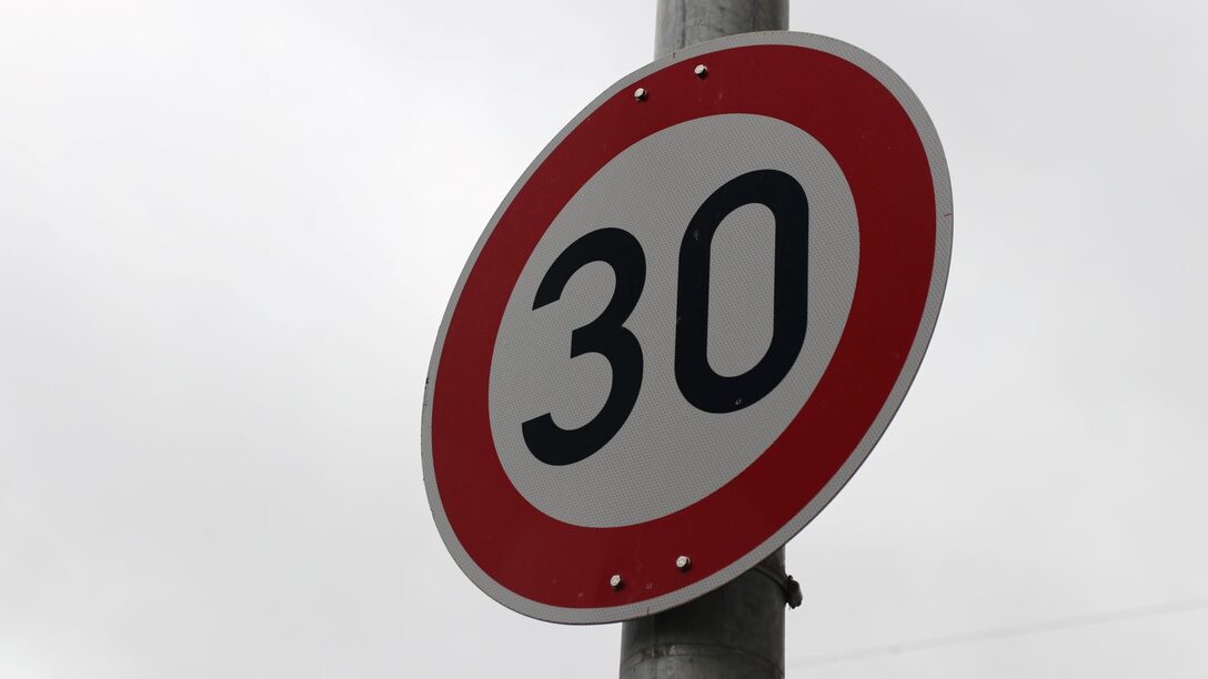 Verkehrsschild "Tempo 30" vor grauem Himmel