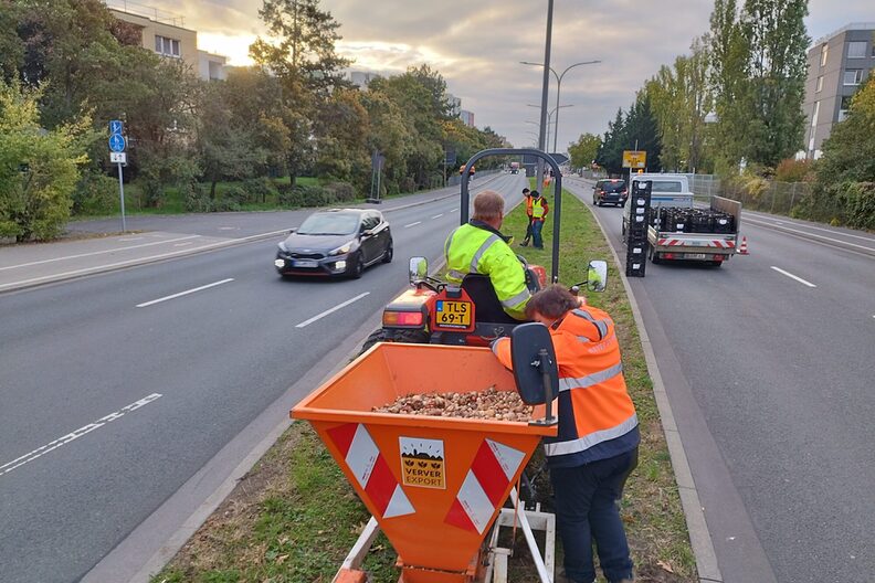 Mit einem Traktor werden auf einem Mittelstreifen Blumenzwiebeln gepflanzt.