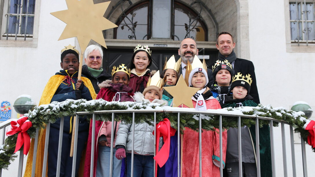 Bürgermeister Murat Karakaya und Stadtrat Simon Valerius gemeinsam mit den Sternensingern vor dem Rathaus in Rüsselsheim am Main