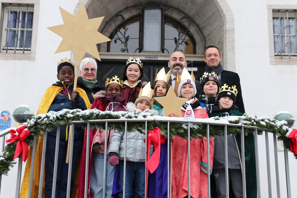 Bürgermeister Murat Karakaya und Stadtrat Simon Valerius gemeinsam mit den Sternensingern vor dem Rathaus in Rüsselsheim am Main