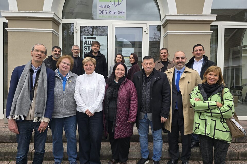 Mehrere Personen stehen vor dem Haus der Kirche in Rüsselsheim