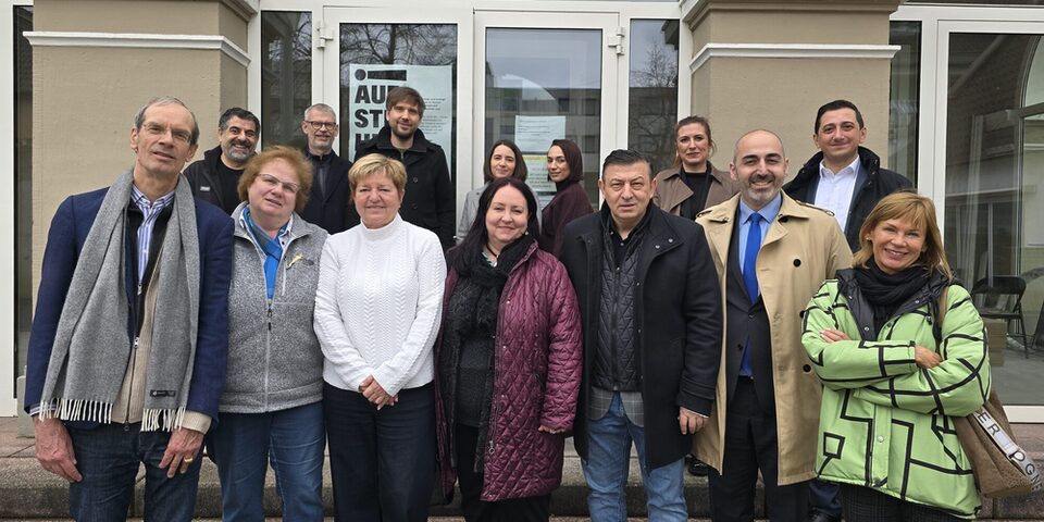 Mehrere Personen stehen vor dem Haus der Kirche in Rüsselsheim