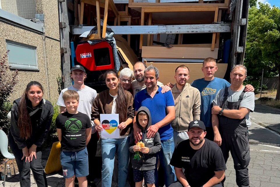 Helfer vor dem gepackten LKW