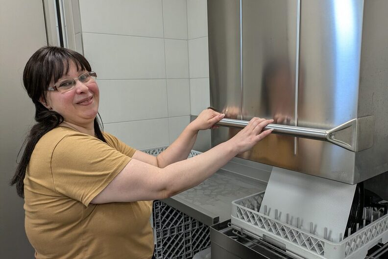Kita-Assistenz an der Spülmaschine der Küche in der Kita Hans-Sachs-Straße