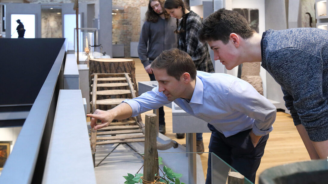 Museumsbesucher lesen aufmerksam eine Informationstafel