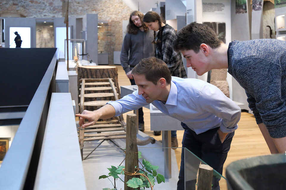 Museumsbesucher lesen aufmerksam eine Informationstafel