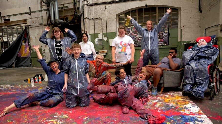 Gruppenbild von Schülerinnen und Schülern in Maleranzügen welches ihr Kunstprojekt vorstellen.