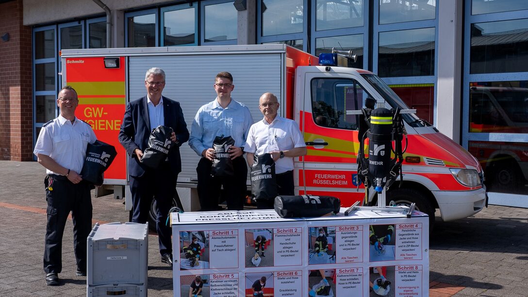 Oberbürgermeister Patrick Burghardt mit drei Feuerwehrmännern