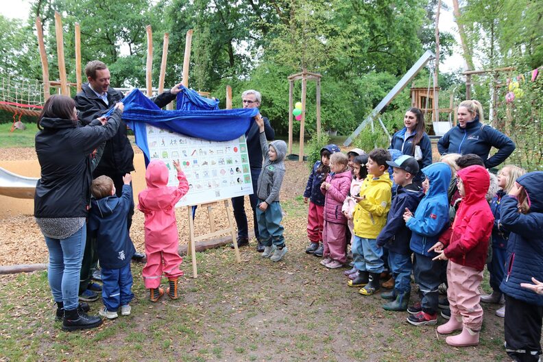 Enthüllung der inklusiven Tafel durch Stadtrat Valerius, Kindergartenkindern und päd. Fachkraft des Kindergartens Bensheimer Straße, Königstädten