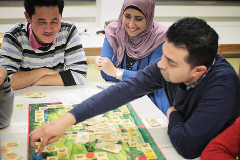 Eine kleine Gruppe Menschen spielt ein Brettspiel
