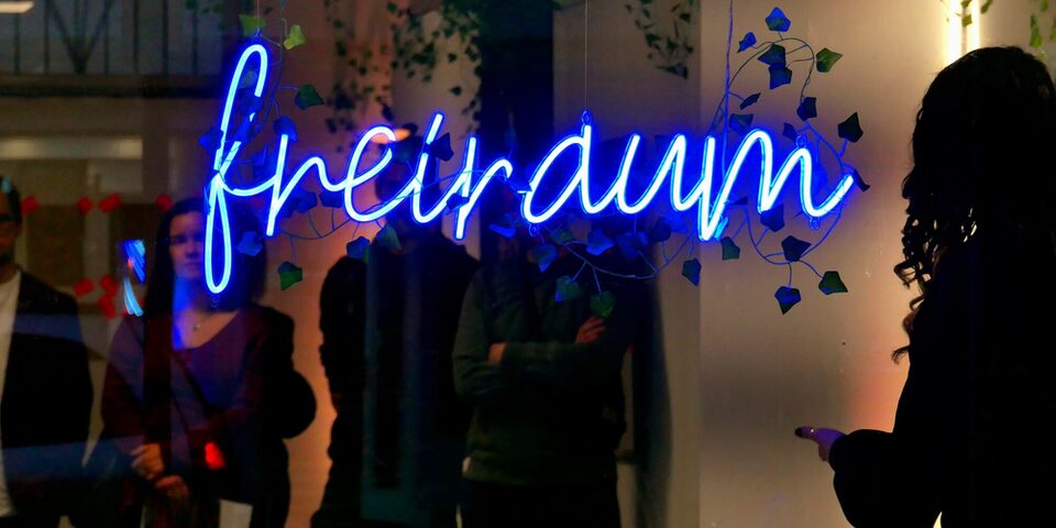 Außenansicht Atelier freiraum f3 bei Nacht, im Schaufenster ist die Leuchtschrift "freiraum" zu sehen