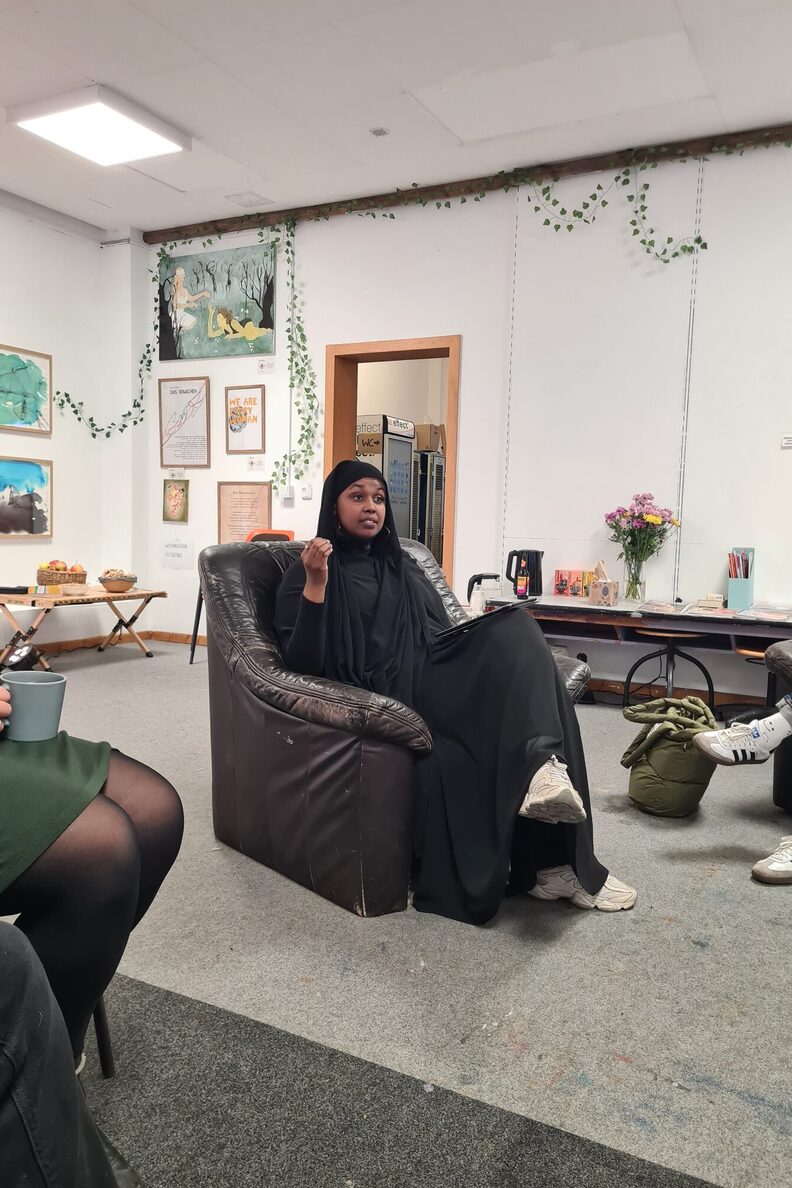 Gesprächsrunde in der Ausstellung „Netzwerk im Dialog“ im freiraum f3, in der Bildmitte sitzt eine Frau in einem Sessel