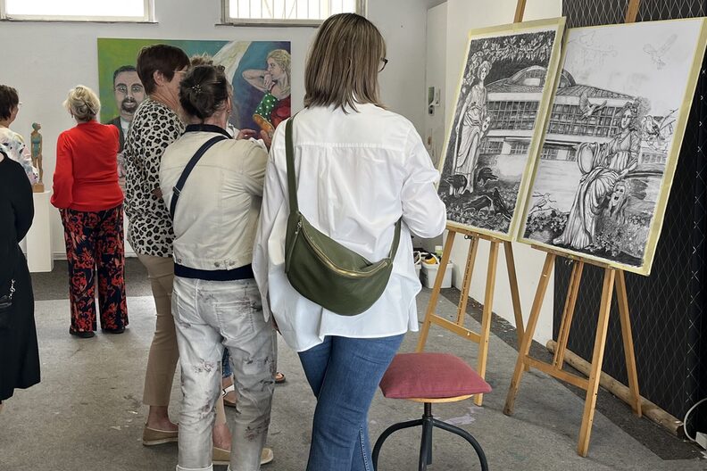 Besucher schauen sich Bilder des Malkastens im freiraum f3 an