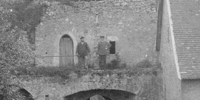 Historisches Foto von zwei Männern, die auf einem Torbogen in der Rüsselsheimer Festung stehen