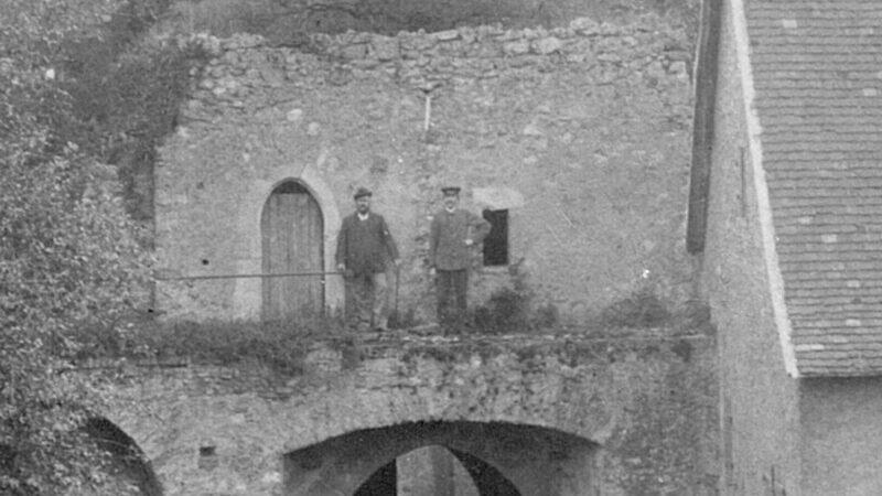 Historisches Foto von zwei Männern, die auf einem Torbogen in der Rüsselsheimer Festung stehen