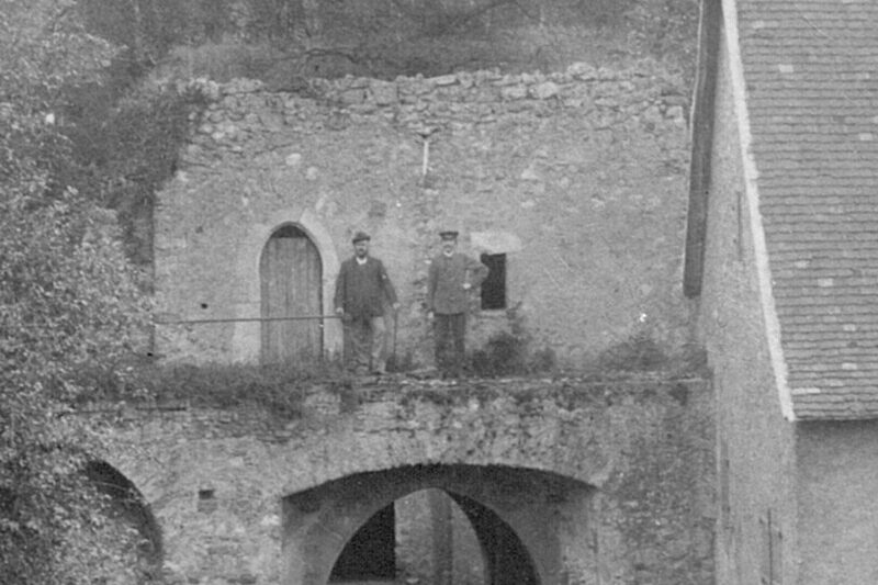Historisches Foto von zwei Männern, die auf einem Torbogen in der Rüsselsheimer Festung stehen