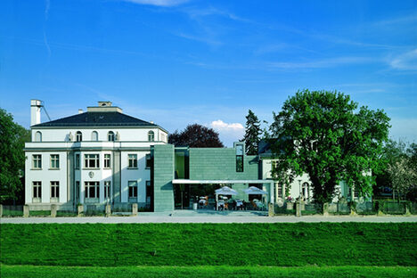 Foto: Weiße Fassade des Museumsgebäudes vom Main aus betrachtet.