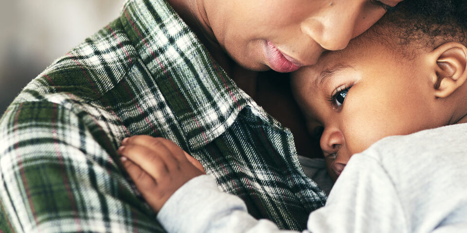 Aufnahme einer Mutter, die ihren kleinen Jungen wiegt