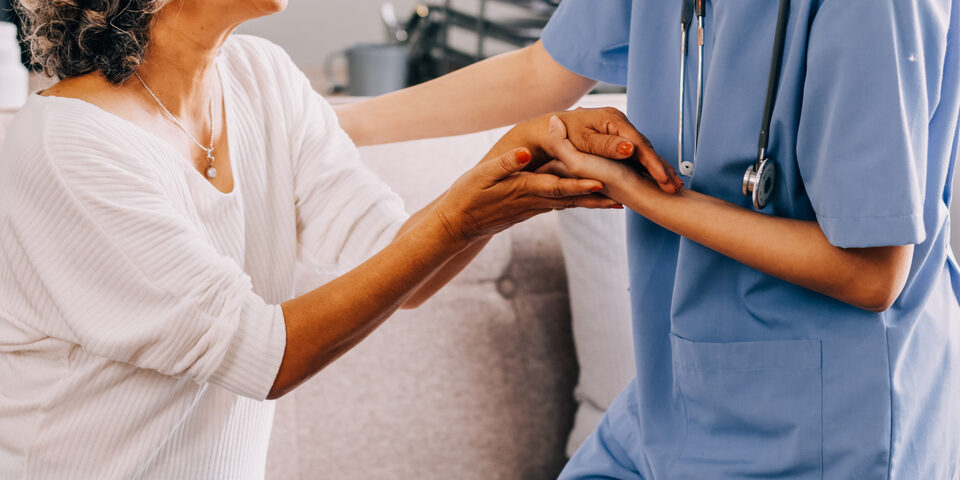 Pflegerin bei einer älteren Dame zum medizinischen Besuch