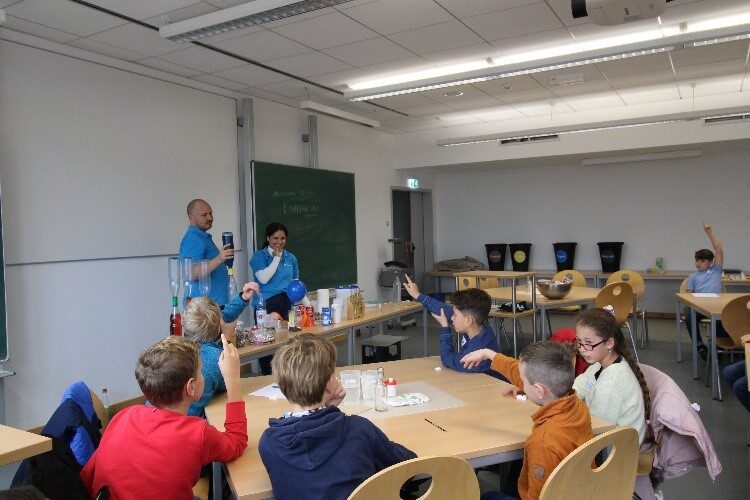 Kinder machen Experimente in einem Seminarraum