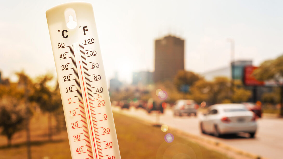 Thermometer vor Autos und Verkehr während einer Hitzewelle