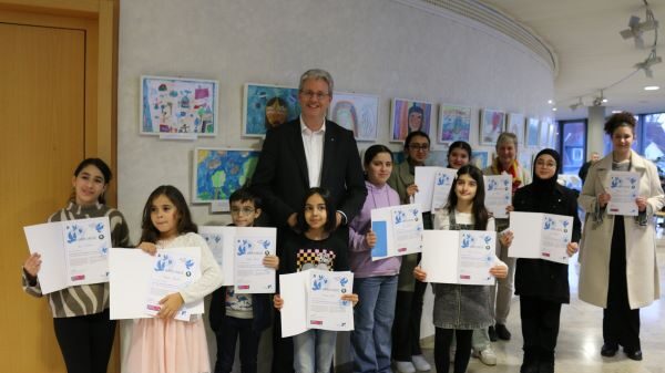 Oberbürgermeister Patrick Burghardt mit den Gewinnerinnen und Gewinnern des Rüsselsheimer Vorentscheides zum Kunstwettbewerb "Was Frieden für mich bedeutet" der Mayors for Peace.